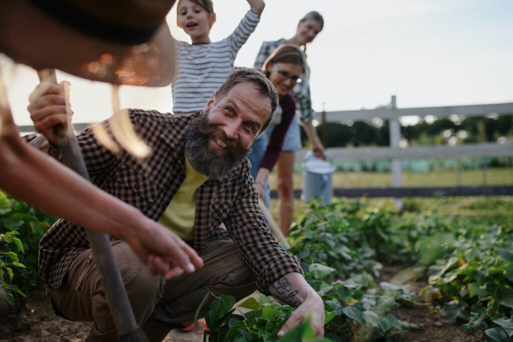 Happy farmers or gardeners working outdoors at community farm